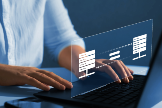 Decorative; close up of hands typing on a laptop, using an enhanced file transfer solution.