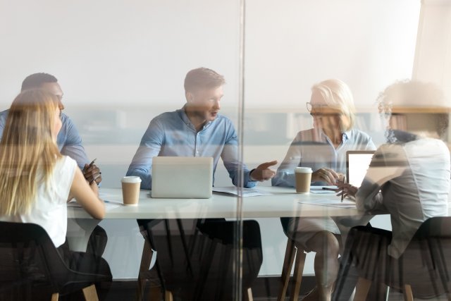 Five people sitting at a conference table