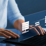 Decorative; close up of hands typing on a laptop, using an enhanced file transfer solution.