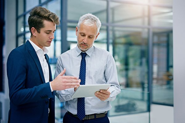 Two men in business clothes review a data security spreadsheet