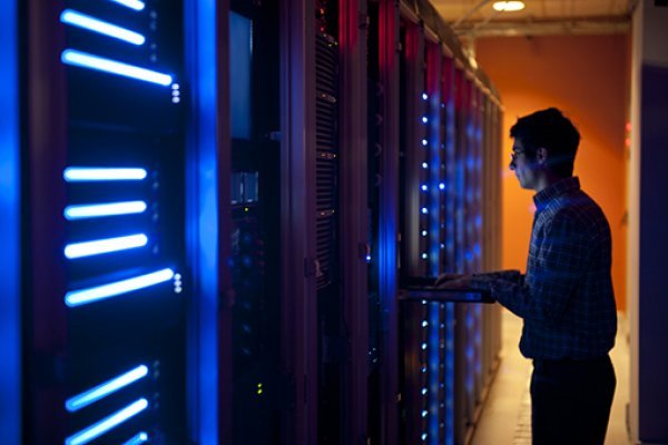 Man holds a laptop up to diagnose server problems.