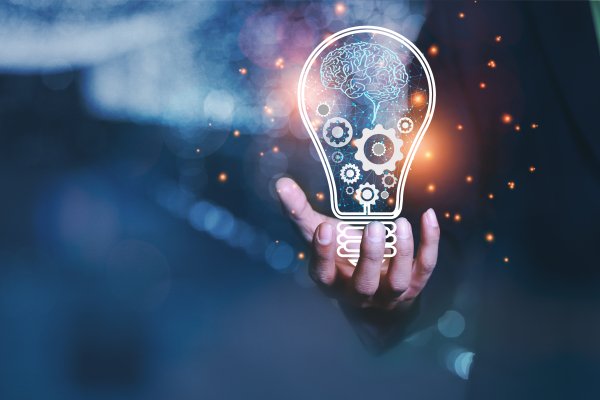 Graphic of hand holding computer generated light bulb.